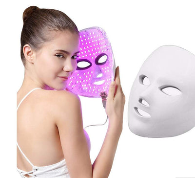 Woman holding 7-color LED facial beauty mask for skin rejuvenation and acne removal therapy