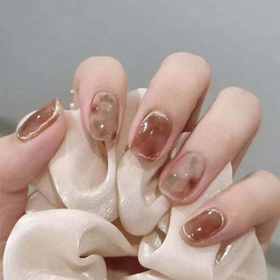 Handmade camellia wearing nail art fake nails with brown translucent design and gold accents on short nails