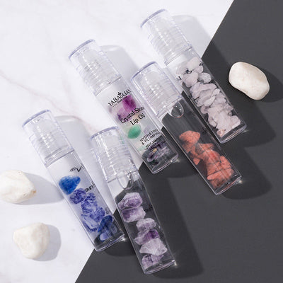 Moisturizing lip care oil with natural crystal stones in clear tubes for hydration and makeup
